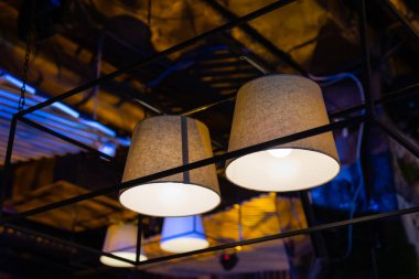 Beyaz ışık topları. Her birinin içinde lamba bulunan toplarla yapılmış modern sanat lüks avizesi gümüş bacaklı güzel bir çiçeğe işaret ediyor. Arka planda tavandan sarkan aydınlatma topu