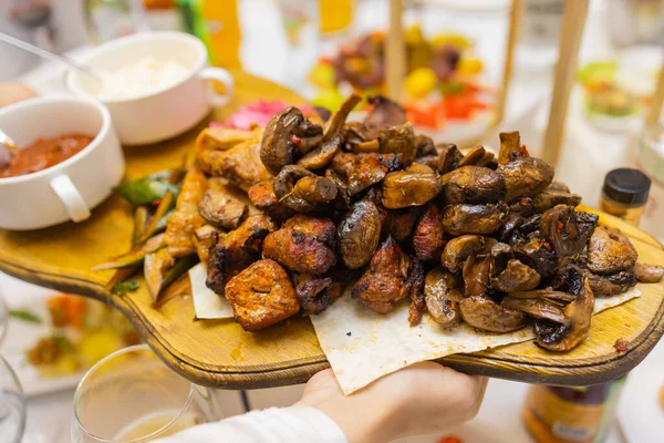 Plat de viande frit sur charbon de bois avec des épices sur une planche de bois. Carré d'agneau, porc, kebab, poulet, champignons et sauces tomate pour la viande. — Photo