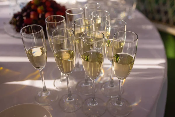 El primer plano de las copas de vino blanco en una fila sobre una mesa. —  Fotos de Stock