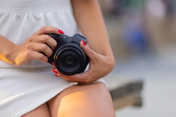Junge attraktive Studentinnen oder Touristinnen mit einer spiegellosen Kamera beim Spaziergang in der Sommerstadt. Frau fotografiert und genießt Wetter. — Stockfoto
