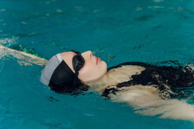 Yüzme havuzunda profesyonel kadın yüzücü eğitimi..