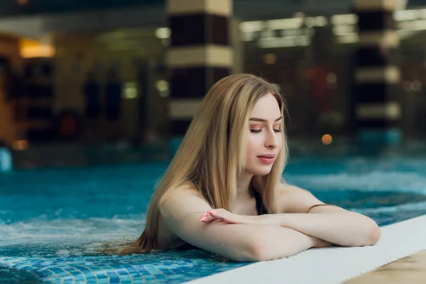 Mooie jonge blonde vrouw bij het zwembad. — Stockfoto