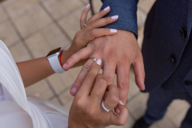 Gelin damat parmağına nikah yüzüğü takıyor..