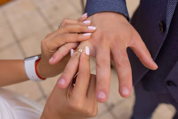 Novia poniendo un anillo de bodas en los novios dedo. — Foto de Stock