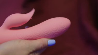 Yatak odasında elinde vibratör tutan bir kadın..