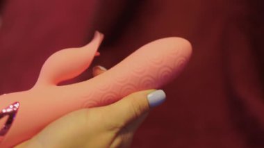 Yatak odasında elinde vibratör tutan bir kadın..