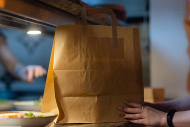 Çağdaş kafe kahve dükkanında, yemek dağıtımında, kafe restoranında, hazır yemek servisinde müşterileri bekleyen tatlı kağıdı torbası..