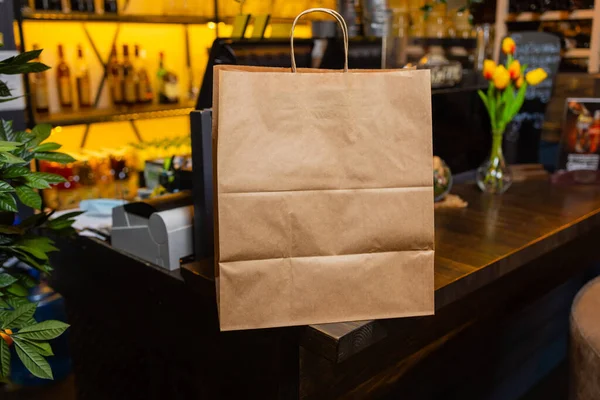 Dessertpapieren zak voor de klant klaar op de toonbank in moderne cafe coffeeshop, levering van voedsel, cafe restaurant, afhaalmaaltijden. — Stockfoto