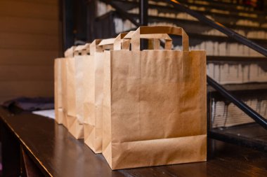 Kurye eve yemek servisi. Kadın kurye siparişi teslim etti. İçinde yemek olan isim çantası yok..