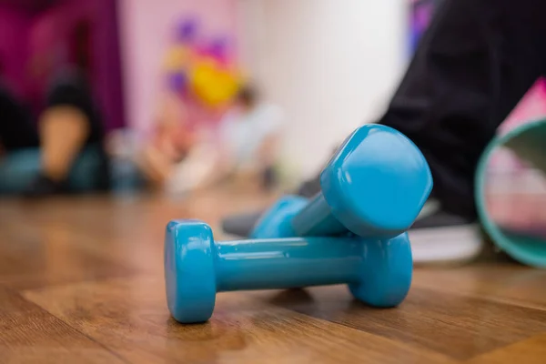 A pair of blue hard plastic hex dumbbells lying on the rubber matted floor of a gym or health club. — Stock Photo, Image
