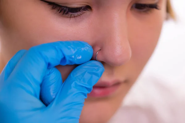 Close-up de uma jovem mulher visagem com piercing pendurado em seu nariz. — Fotografia de Stock