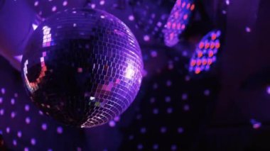 Disko ayna topu dönüyor ve ışığı yansıtıyor.