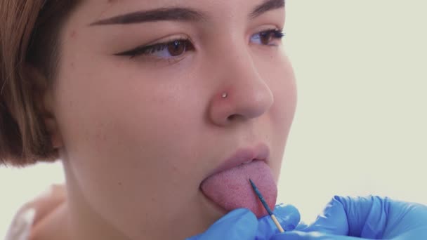 Primer plano retrato de la joven mujer caucásica sobresaliendo de la lengua perforada . — Vídeo de stock