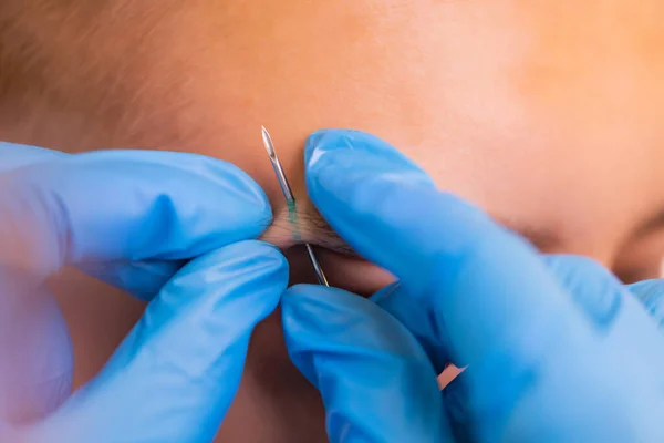 Man met doorboorde wenkbrauw. Drie kleine zwarte piercings. — Stockfoto