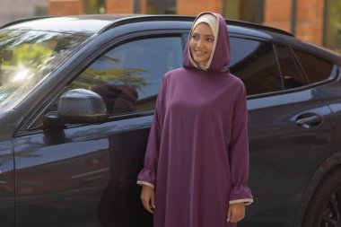 Müslüman elbiseli güzel bir kadın yaz parkı arka planında duruyor sonbahar ağaçları. Dünya tesettür günü..