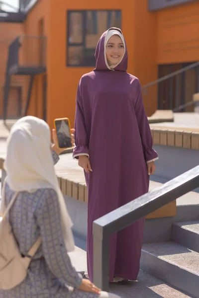 Islamische schöne Frau in einem muslimischen Kleid steht auf einem Sommer Park Straße Hintergrund Wald Herbst Bäume. Welt Hijab Tag. — Stockfoto