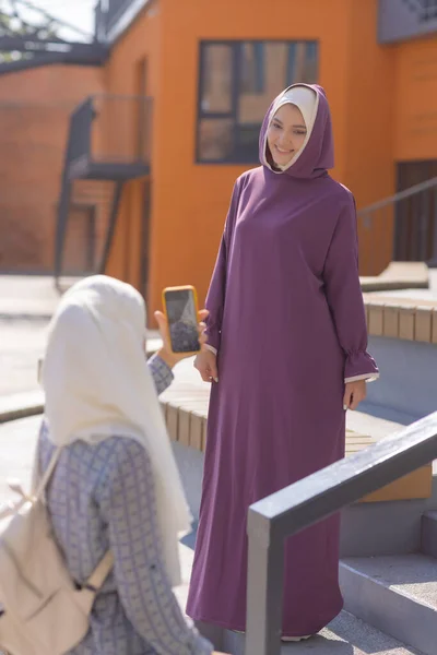 Islamische schöne Frau in einem muslimischen Kleid steht auf einem Sommer Park Straße Hintergrund Wald Herbst Bäume. Welt Hijab Tag. — Stockfoto