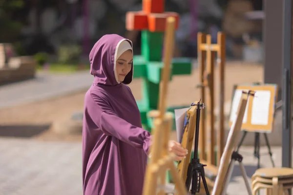 Islamitische prachtige vrouw in een islamitische jurk staande op een zomer park straat achtergrond bos herfst bomen.wereld hijab dag. — Stockfoto