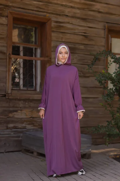 Islamische schöne Frau in einem muslimischen Kleid steht auf einem Sommer Park Straße Hintergrund Wald Herbst Bäume. Welt Hijab Tag. — Stockfoto