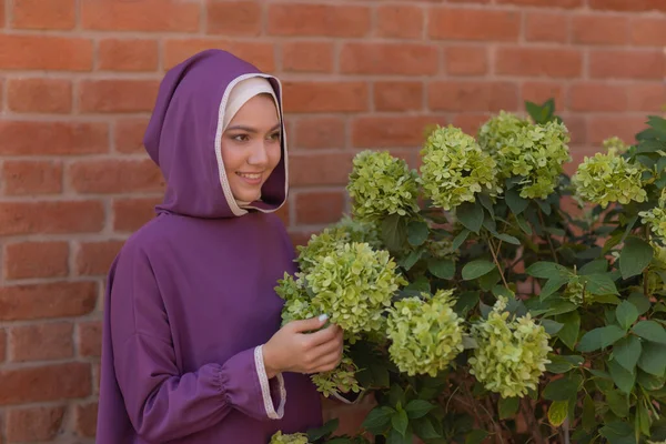 Islamische schöne Frau in einem muslimischen Kleid steht auf einem Sommer Park Straße Hintergrund Wald Herbst Bäume. Welt Hijab Tag. — Stockfoto