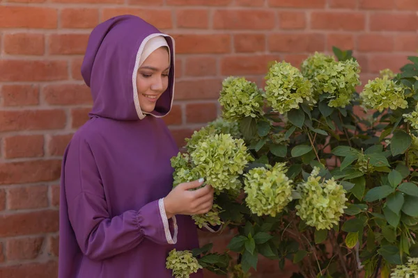 Islamische schöne Frau in einem muslimischen Kleid steht auf einem Sommer Park Straße Hintergrund Wald Herbst Bäume. Welt Hijab Tag. — Stockfoto