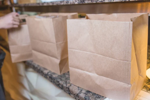 Koerier levering food service thuis. Vrouw koerier geleverd de bestelling geen naam tas met voedsel. — Stockfoto