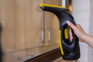 İş kıyafetleri içinde, evdeki profesyonel aletlerle pencereleri yıkayan güzel bir ev hanımı..