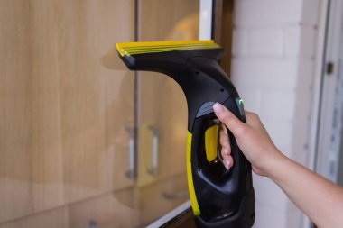 İş kıyafetleri içinde, evdeki profesyonel aletlerle pencereleri yıkayan güzel bir ev hanımı..