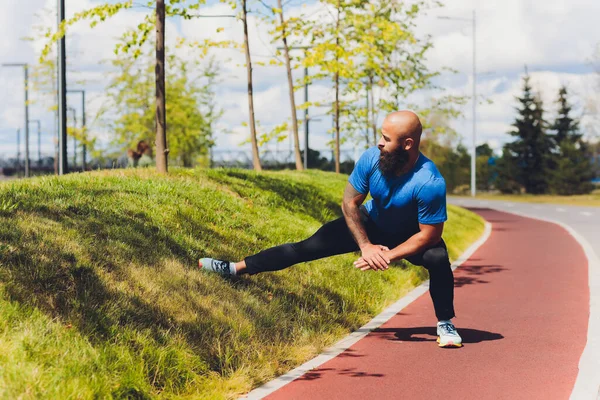 Młody sportowiec biegnie szybko na świeżym powietrzu. Ubrany w sportowy materiał, robi szeroki krok, demonstruje zdrowy styl życia, szerokie ujęcie. — Zdjęcie stockowe