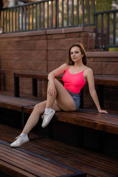 Portret van een jonge mooie vrouw in blauwe korte broek residentieel complex. — Stockfoto