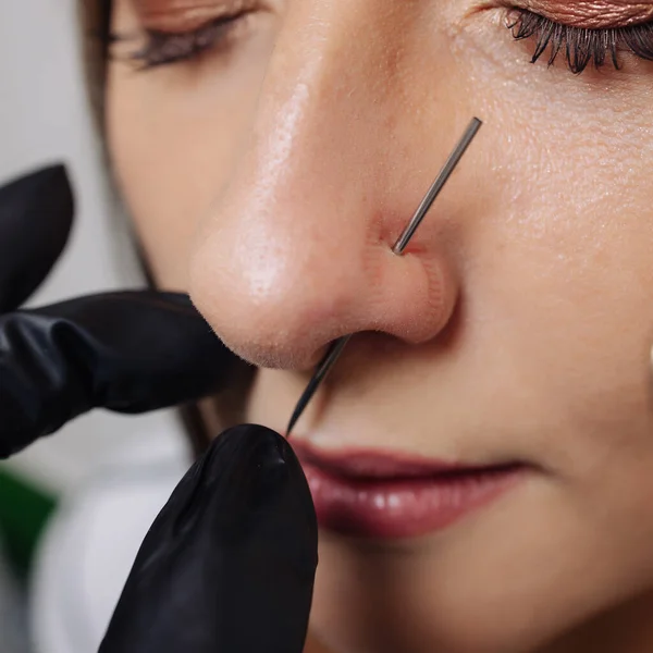 Close-up de uma jovem mulher visagem com piercing pendurado em seu nariz. — Fotografia de Stock