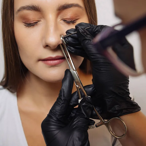 Close-up de uma jovem mulher visagem com piercing pendurado em seu nariz. — Fotografia de Stock
