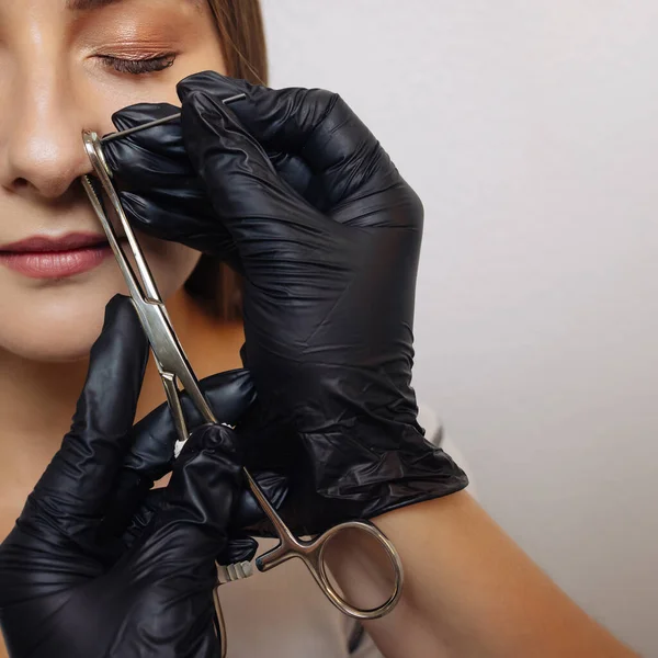 Close-up de uma jovem mulher visagem com piercing pendurado em seu nariz. — Fotografia de Stock