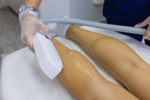 Beautist ger Epilation Laser behandling till kvinna på lår. — Stockfoto