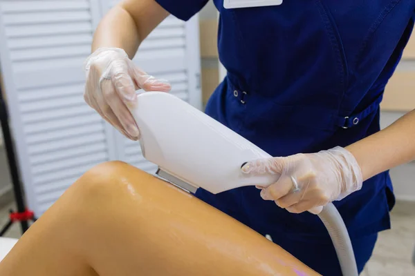 Косметолог дає лазерне лікування жінці на стегні . — стокове фото