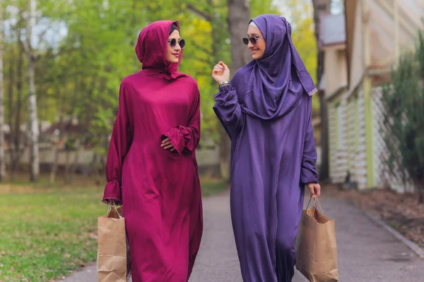 Islamitische prachtige vrouw in een islamitische jurk staande op een zomer park straat achtergrond bos herfst bomen.wereld hijab dag. — Stockfoto