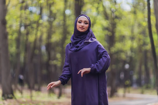 Islamic beautiful woman in a Muslim dress standing on a summer park street background forest autumn trees.world hijab day. — Stock Photo, Image