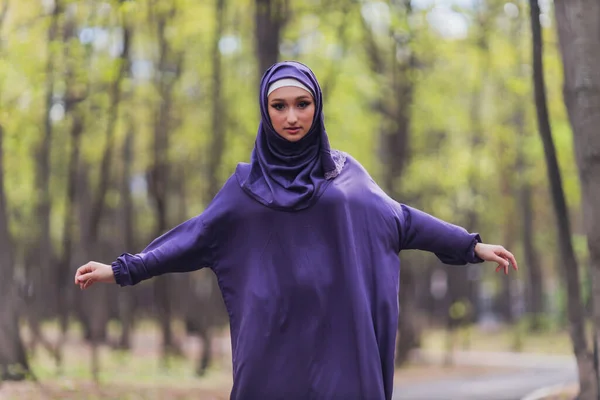 Mujer hermosa islámica en un vestido musulmán de pie en un parque de verano calle fondo bosque otoño trees.world hijab día. — Foto de Stock