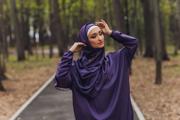 Mujer hermosa islámica en un vestido musulmán de pie en un parque de verano calle fondo bosque otoño trees.world hijab día. — Foto de Stock