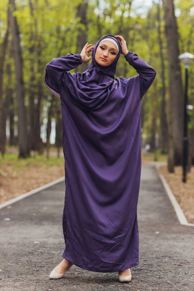 Mujer hermosa islámica en un vestido musulmán de pie en un parque de verano calle fondo bosque otoño trees.world hijab día. — Foto de Stock