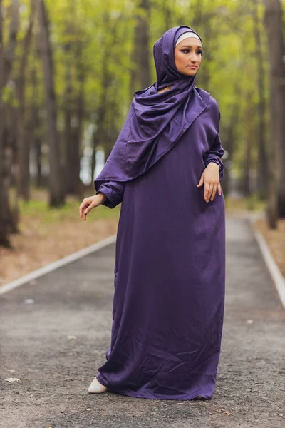 Mujer hermosa islámica en un vestido musulmán de pie en un parque de verano calle fondo bosque otoño trees.world hijab día. — Foto de Stock