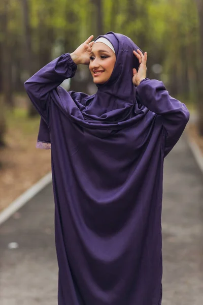 Mujer hermosa islámica en un vestido musulmán de pie en un parque de verano calle fondo bosque otoño trees.world hijab día. — Foto de Stock