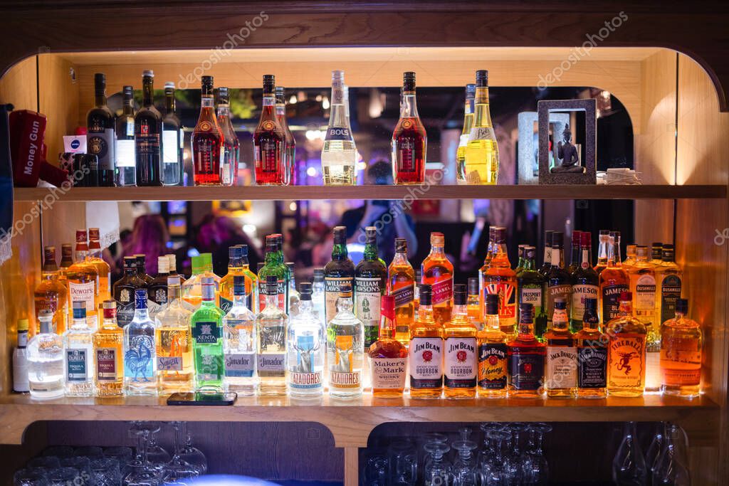 Ufa, Russia, 1 July, 2021: Several types of bottled alcohol are displayed on some shelves in a pub