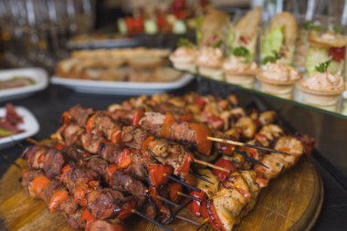 Tabakta çeşit çeşit et var. Bir yığın halinde farklı et ve patates türleri. Büyük bir tabakta soslu aperatif..