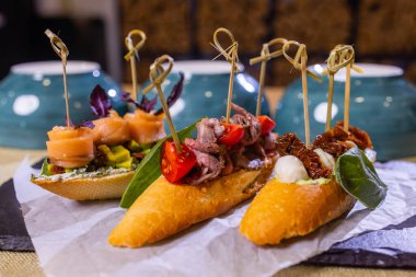 Közlenmiş domates, mozzarella peyniri, sarmısak ve otlar ile İtalyan meze bruschetta.