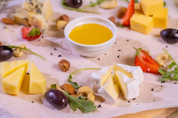 Placa de queso con quesos Dorblu, Parmesano, Brie, Camembert y Roquefort en servir sobre la mesa de un viejo árbol de cerca . —  Fotos de Stock