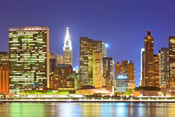 New York City, USA. Downtown buildings in Manhattan with colorful lights, panorama at sunset