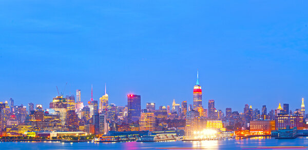 New York City skyline at sunset with illuminated business buildings