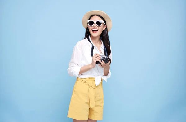 幸せなアジアの女性は写真カメラを保持し 離れて青の背景の上に隔離された見て夏服を着て — ストック写真