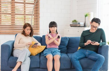 Evde tablet ve cep telefonu kullanan Asyalı bir ebeveyn. aygıtlara bağımlı, aygıtlara bağımlı aşırı kullanım.